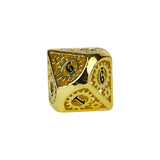 Gold metal dice with embossed numbers on a white background