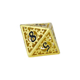 Gold-colored die with black symbols on a white background