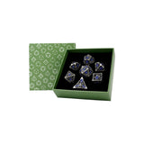 Set of dice with blue and silver accents in a green box with geometric pattern