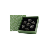 Set of dice with a green box featuring geometric patterns on a white background