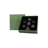 Set of crystal dice in a green box with geometric pattern