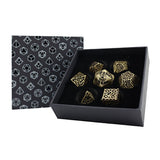 Set of gold dice with intricate designs in a black box with geometric pattern