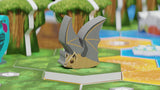 Board game piece resembling a bat on a game board with trees and paths in the background