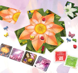 Board game cards with colorful designs on a light pink background