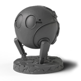 A matte dark gray miniature figurine of a spherical robot or droid standing on a textured round base, shown against a plain white background with a soft shadow.