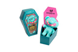 Zombie bear plush toy in a teal coffin-shaped box with 'Zombear' branding.