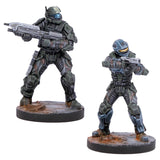 Two miniature figures of futuristic soldiers on stands with a white background