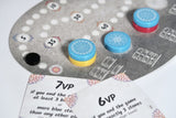 Close-up of a board game with chips and cards on a gray surface