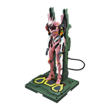 A pink and white mecha figurine standing on a green display base with yellow accents, photographed against a plain white background.