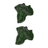Two green pins with leaf designs on a white background