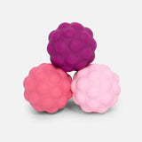 Three textured pink and purple balls on a light gray background