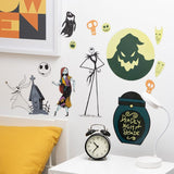 A set of Halloween-themed wall decals featuring Jack Skellington, Sally, the haunted house, a pumpkin moon, and a jar labeled 'Deadly Night Shade' displayed on a white wall above a bedside table with a clock and lamp.