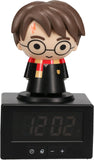Figurine of a character in a robe with glasses on top of a digital clock.