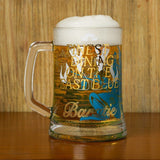 Glass mug with beer and decorative text on a wooden surface