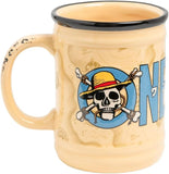 A ceramic coffee mug with a beige and light brown map pattern, featuring the One Piece skull and crossbones logo with a straw hat on a blue circle, and the letter 'N' on the side. The mug has a black rim and a distressed handle.