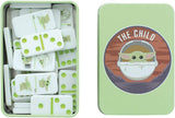 A boxed set of white dominoes with light green pips and character graphics, shown open next to its mint green tin lid. The lid features a circular illustration of Grogu from The Child wearing a spacesuit with the text 'THE CHILD' at the top.