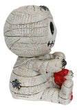 Mummy figurine holding a red heart on a white background