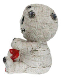Mummy figurine with a red bow on a white background