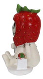 Small figurine with a strawberry on its head against a white background