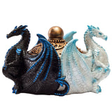 A decorative resin figurine of two dragons facing each other, with a gold-toned orb on a chain resting on their backs. The left dragon is black with bright blue accents, and the right dragon is white with light blue accents.