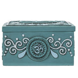 Decorative teal box with Om symbol and intricate designs on a white background