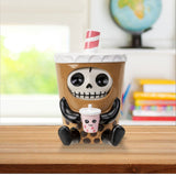 Squeezable toy shaped like a coffee cup with a skeleton design on a wooden surface.