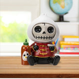 Skeleton figurine with a hot sauce bottle on a desk