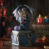 Fantasy figurine of a dragon-like creature holding a purple orb on a dark background.