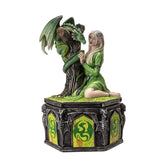 Statue of a woman in green attire sitting next to a dragon on a pedestal with decorative elements.