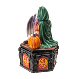 Statue of a figure in a green cloak with a pumpkin on a white background