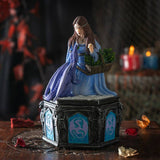 Decorative figurine of a woman with plants on a dark background