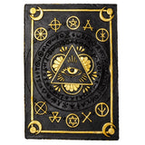 Decorative plaque with gold symbols and an eye design on a black background