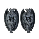 A pair of gothic gargoyle wall bookends featuring detailed sculpted gargoyle figures with spread wings, seated on a pedestal and holding a baby, in a dark textured finish against a plain white background.