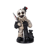 Horror-themed clown figurine holding a knife on a white background