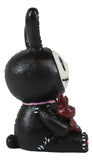 Black rabbit figurine with a white face and red heart on a white background