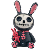 Skull-shaped toy with bunny ears and a small red rabbit plushie on a white background