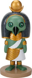 A stylized Egyptian bird figurine with green skin, a black headdress, gold jewelry and crown details, and a white sash, standing on a round tan base against a white background.