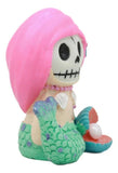 Mermaid skeleton figurine with pink hair and green tail on a white background