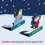 Cartoon characters Linus and Charlie Brown in a snowy scene with Christmas tree, featuring Standee Cards branding.