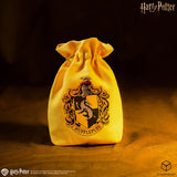 Yellow drawstring bag with Hufflepuff crest on a dark background