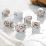 White dice with gold numbering on a white surface