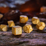 Gold dice with intricate designs on a textured surface