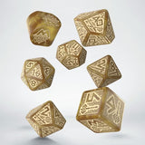 Set of gold polyhedral dice with intricate patterns on a white background