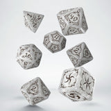Set of silver polyhedral dice with black engravings on a white background