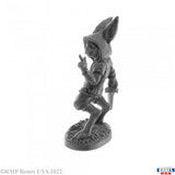 Gray miniature figurine of a character with pointed ears on a white background