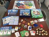 Board game components on a table including cards, pieces, and a board.