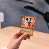 Hand holding a trading card featuring Mickey Mouse against a blurred background