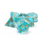 Set of turquoise polyhedral dice with gold numbers on a white background