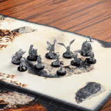 Set of miniature figurines on a game board with a wooden surface