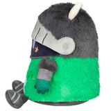 Plush toy resembling a character with green body, gray helmet, and white horns on a white background